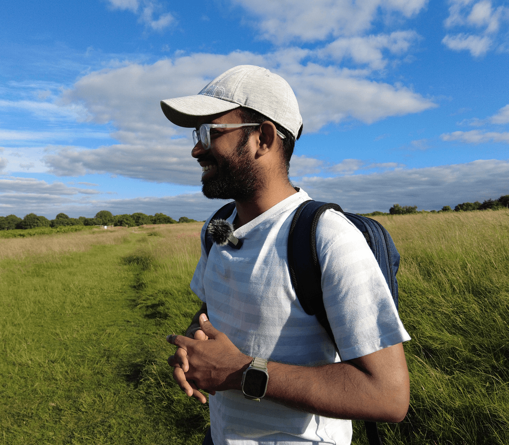 Lak walking through a grassy field under a wide blue sky