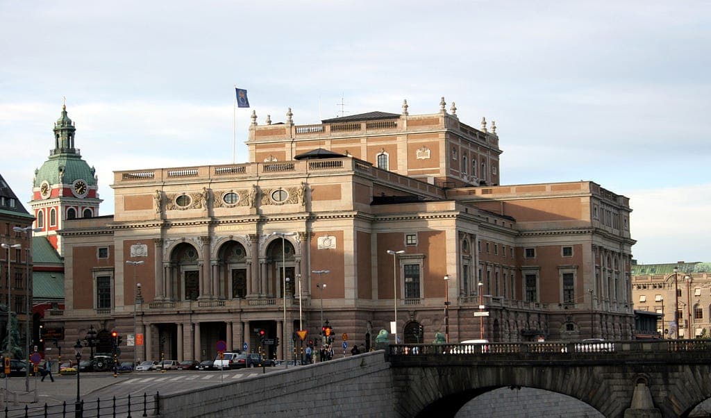 A grand brick building beside a city canal and bridge