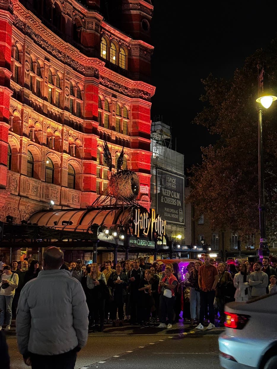 Crowds outside the Harry Potter and the Cursed Child theatre in London at night