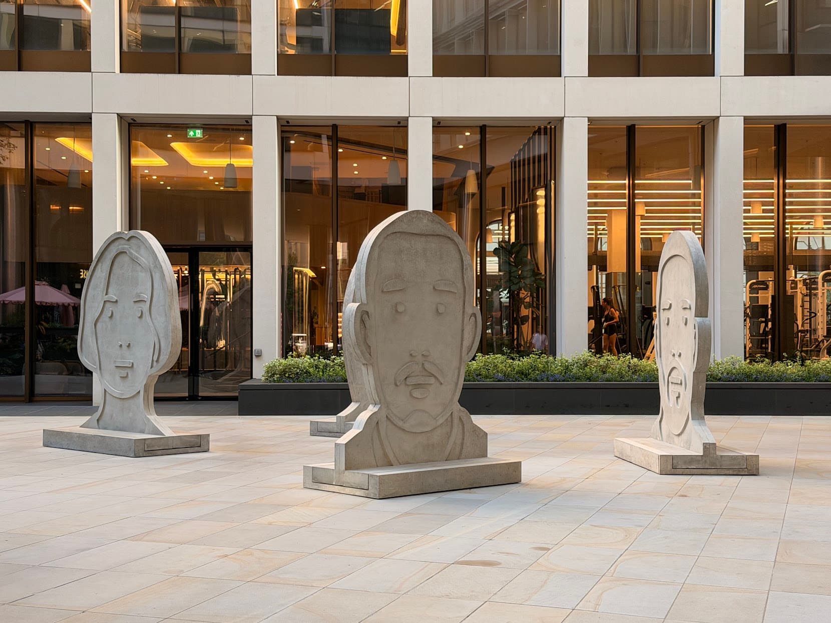 Large stone face sculptures in a modern courtyard
