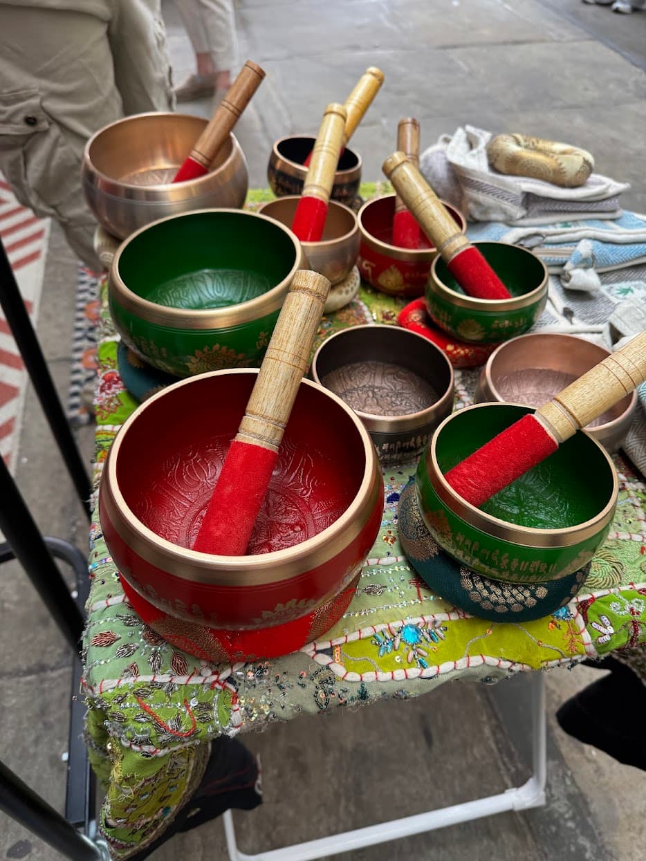 Colourful singing bowls arranged at a market stall
