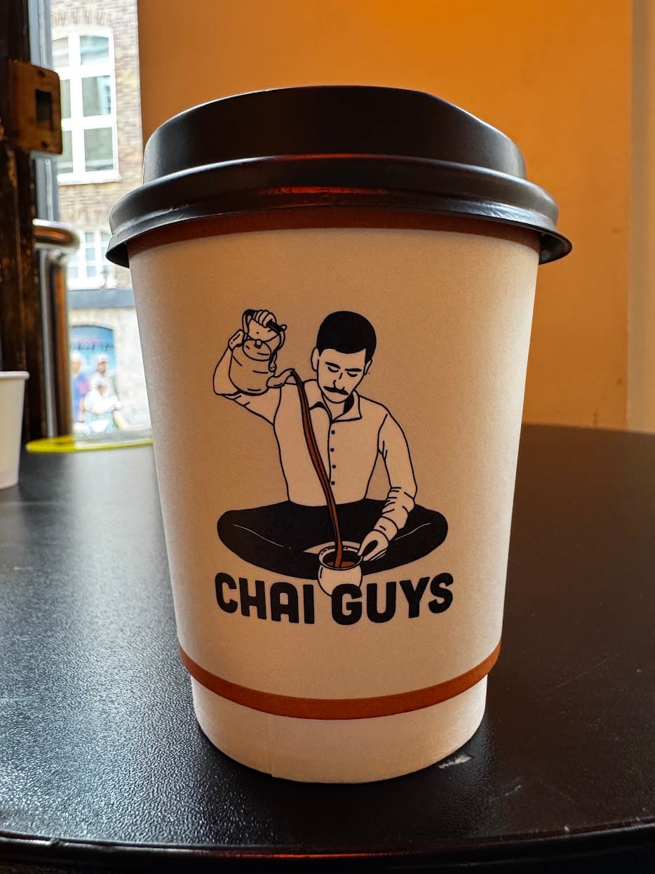 A Chai Guys cup on a cafe table