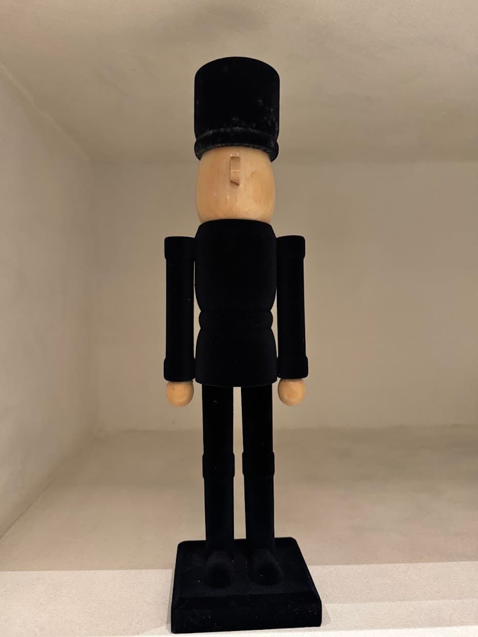 A minimal wooden guard figure in black